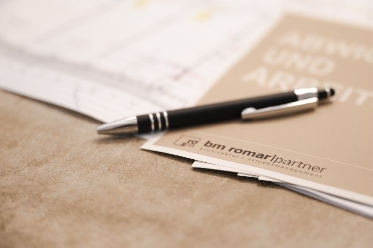 Architektenteam von BM Romar | Partner bei der digitalen Projektplanung am Computer mit Bauplänen.